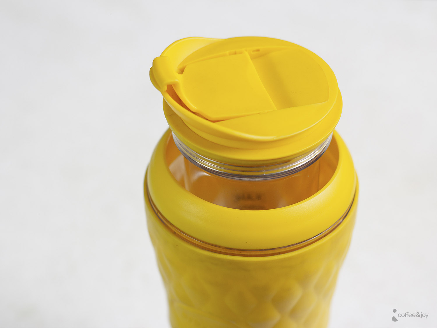 Detalhe da tampa de uma pressca amarela, ideal para preparar e transportar café em qualquer lugar.